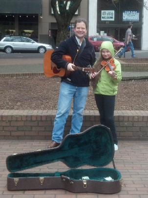Street musicians performing at a Tidbits of Change event